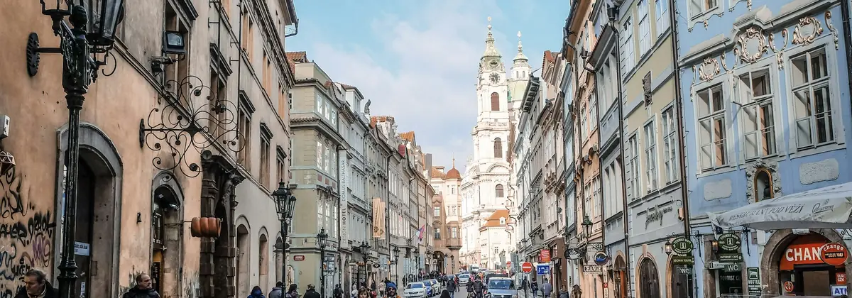 Obiskovalci, ki se sprehajajo po tlakovani ulici evropskega starega mesta
