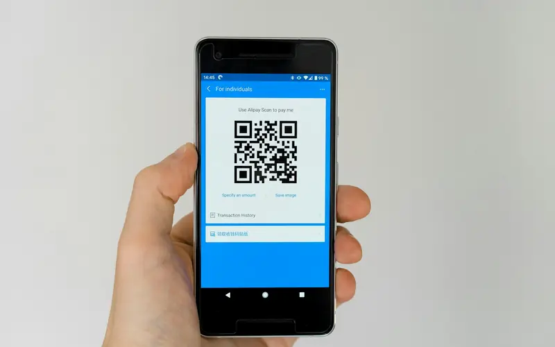A hand holding a phone showing an eSIM installation QR code